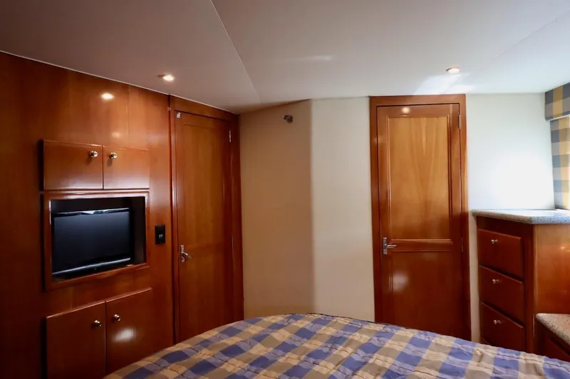 Grace Wins II Yacht Photos Pics Interior of 2001 Carver 406 Motor Yacht bedroom with wood paneling and built-in TV.