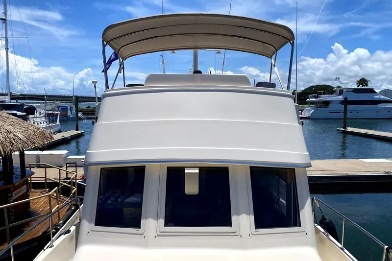 Hellion Yacht Photos Pics 2005 Mainship 34 Trawler docked at marina under clear blue sky.