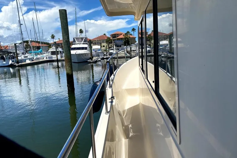 Hellion Yacht Photos Pics 2005 Mainship 34 Trawler docked at marina, sunny day, clear reflections on water.