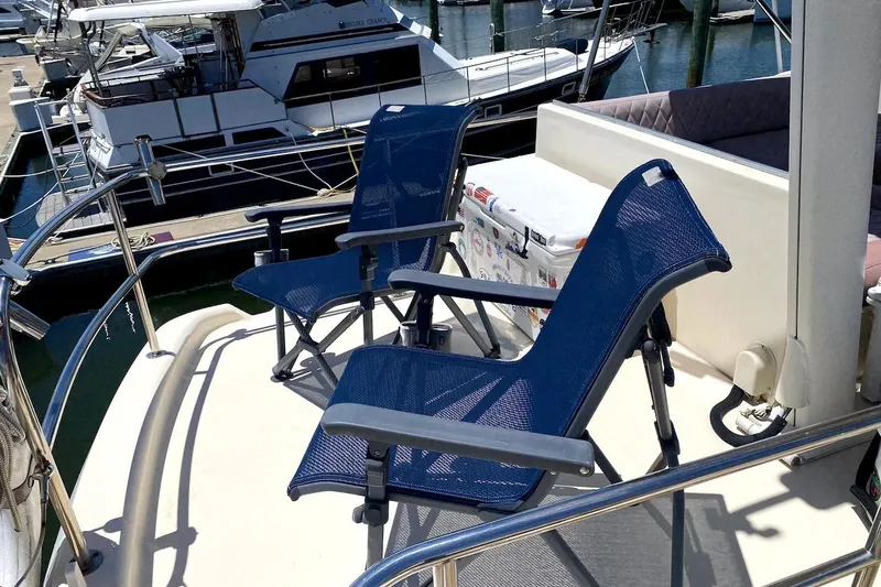 Hellion Yacht Photos Pics Deck of 2005 Mainship 34 Trawler with blue chairs and cooler.