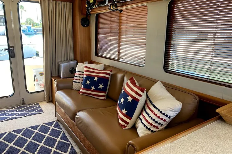 Hellion Yacht Photos Pics Interior of 2005 Mainship 34 Trawler with patriotic-themed pillows on a leather sofa.