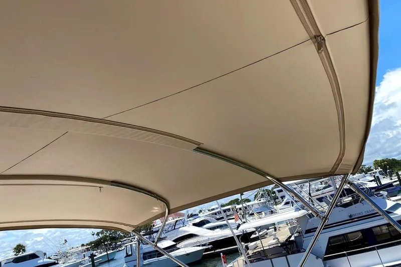 Hellion Yacht Photos Pics Bimini top of 2005 Mainship 34 Trawler at marina, showcasing boat canopy design.