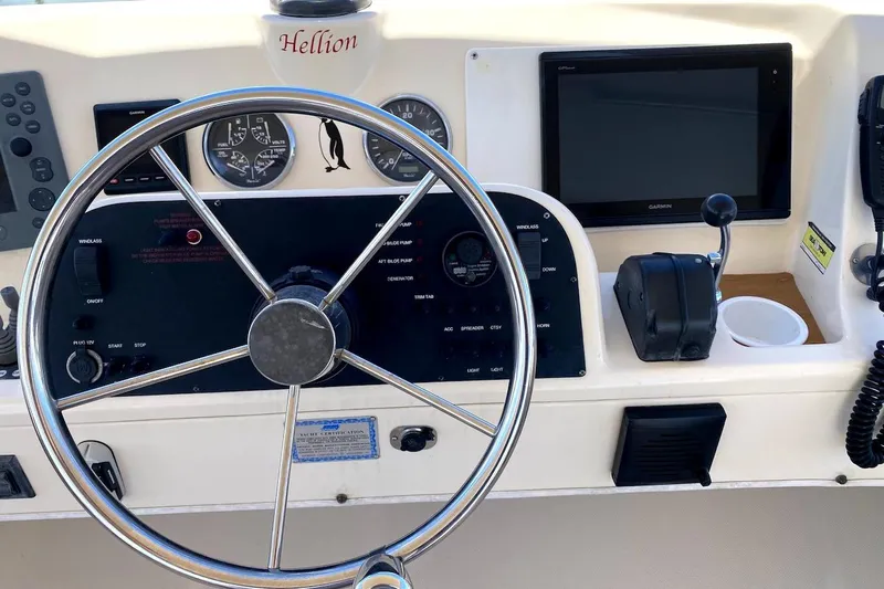 Hellion Yacht Photos Pics Helm of 2005 Mainship 34 Trawler with steering wheel, gauges, and navigation equipment.