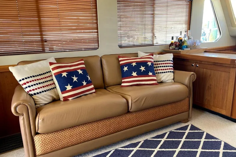 Hellion Yacht Photos Pics Luxurious 2005 Mainship 34 Trawler interior with patriotic-themed cushions on a leather sofa.