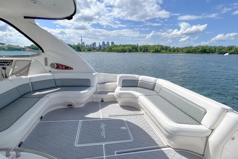  Yacht Photos Pics 1998 Sea Ray 540 Sundancer yacht with spacious seating, city skyline in background.
