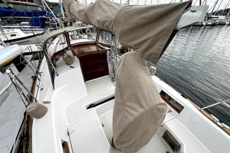  Yacht Photos Pics 2004 Pacific Seacraft 31 sailboat deck with covered equipment, docked at marina.