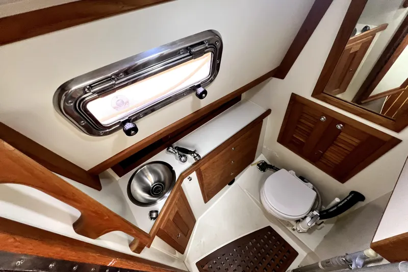  Yacht Photos Pics 2004 Pacific Seacraft 31 yacht bathroom with wooden cabinetry and stainless steel sink.