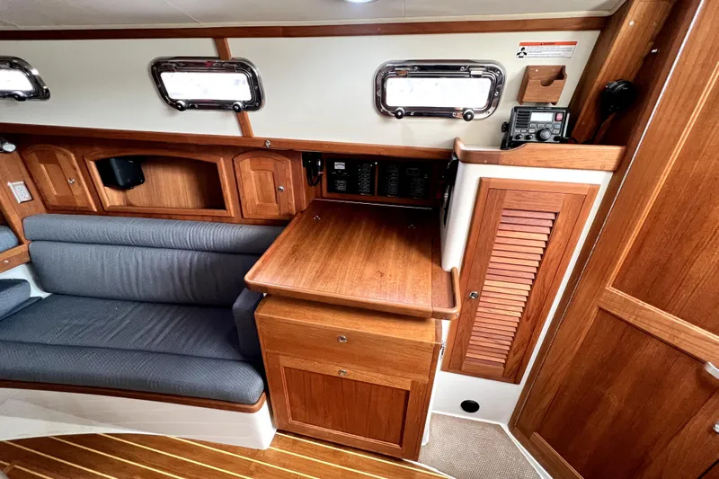  Yacht Photos Pics Interior of 2004 Pacific Seacraft 31 sailboat with wooden cabinetry and seating area.