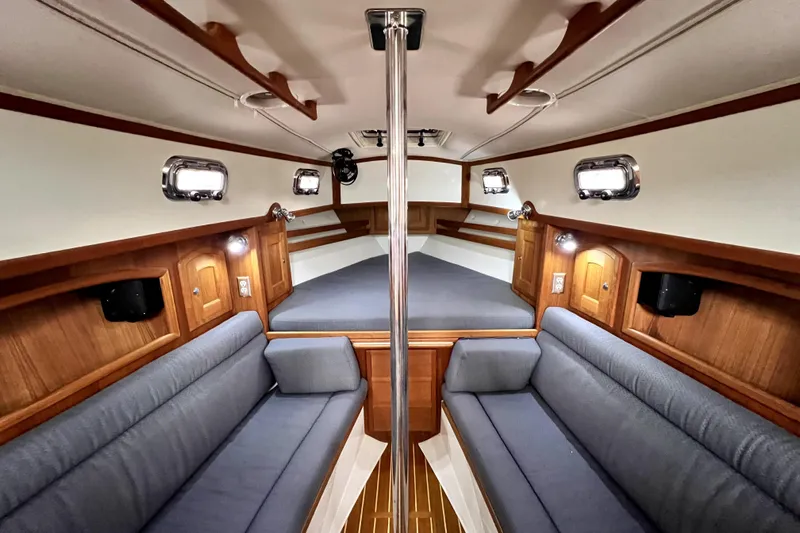  Yacht Photos Pics Interior of 2004 Pacific Seacraft 31 sailboat with cozy seating and wooden accents.