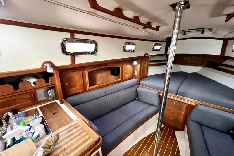  Yacht Photos Pics Interior of 2004 Pacific Seacraft 31 sailboat with cozy seating and wooden cabinetry.