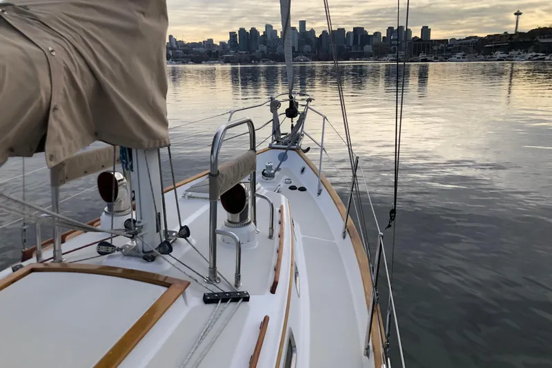 Murphy Yacht Photos Pics Sailboat Pacific Seacraft 31, 2004 model, on calm water with city skyline backdrop.