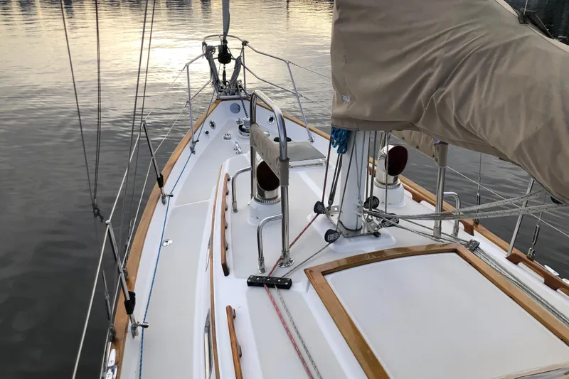 Murphy Yacht Photos Pics 2004 Pacific Seacraft 31 sailboat deck with wooden trim and covered mast, docked on calm water.