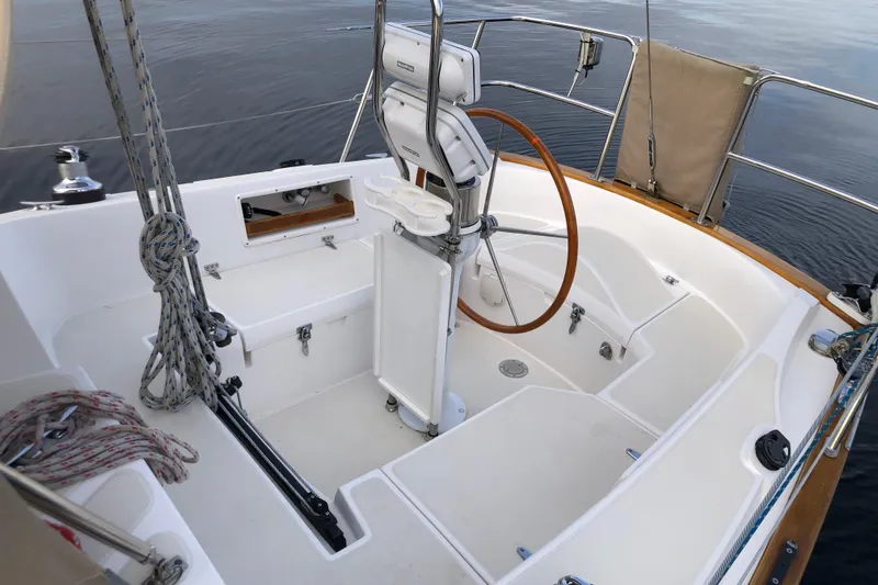 Murphy Yacht Photos Pics Cockpit of 2004 Pacific Seacraft 31 sailboat with wooden steering wheel and ropes.