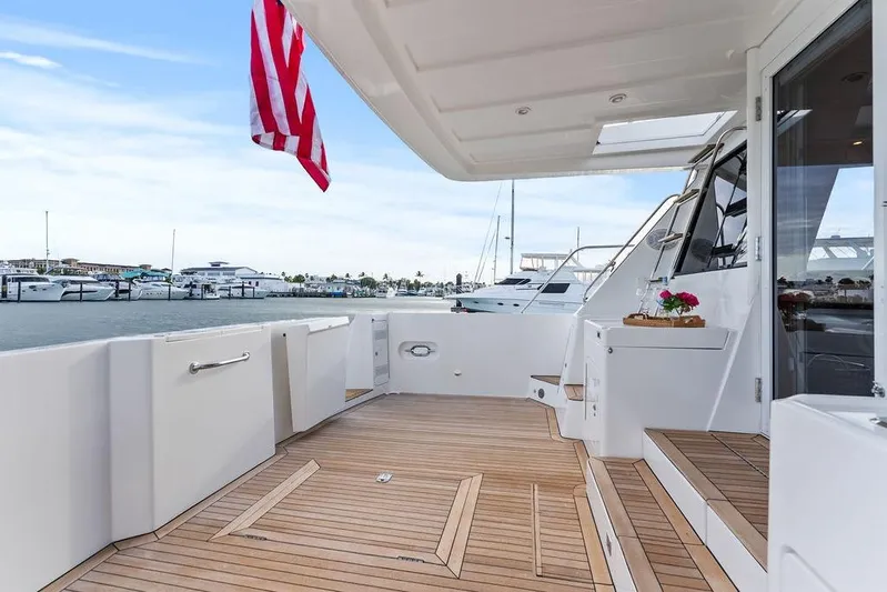 Five O' Clock Yacht Photos Pics Luxurious 2000 West Bay 58 Sonship yacht deck with elegant wood flooring and marina view.