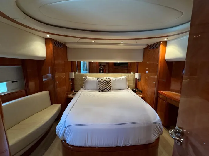  Yacht Photos Pics Luxurious bedroom interior of a 1998 Azimut Ultimate yacht with elegant wood paneling.