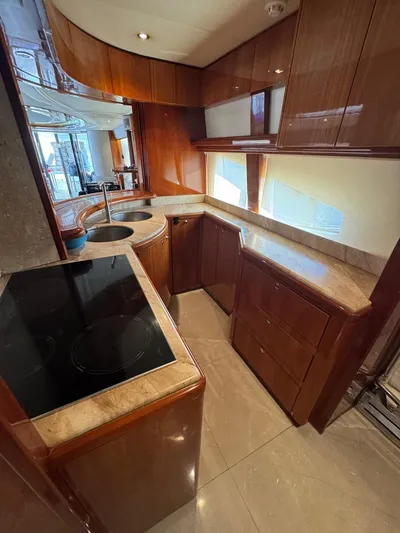  Yacht Photos Pics Luxurious kitchen interior of 1998 Azimut Ultimate yacht with wood cabinetry and modern appliances.