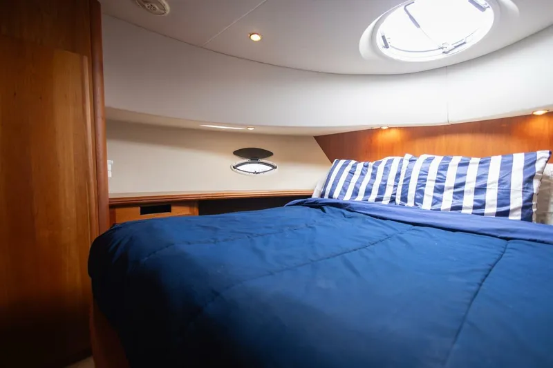 Blue Sapphire Yacht Photos Pics Interior cabin of 2001 Silverton 410 Sport Bridge with blue bedding and striped pillows.