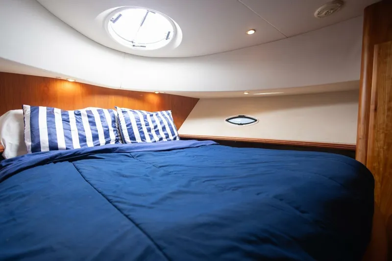 Blue Sapphire Yacht Photos Pics Cozy cabin interior of 2001 Silverton 410 Sport Bridge with blue bedding and striped pillows.