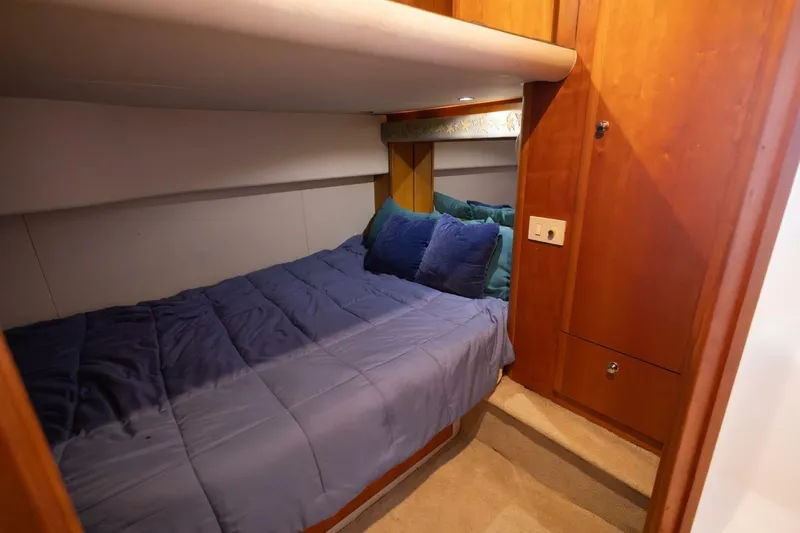 Blue Sapphire Yacht Photos Pics Cozy cabin interior of 2001 Silverton 410 Sport Bridge with plush bedding and wooden cabinetry.