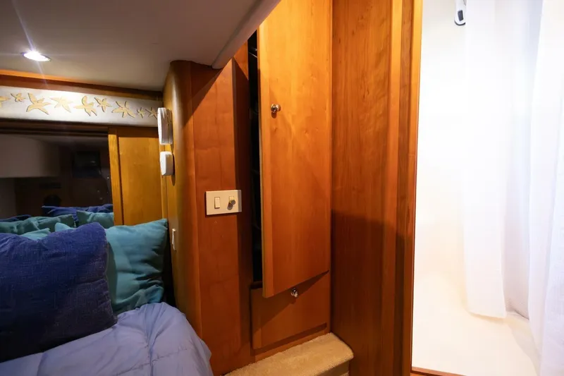 Blue Sapphire Yacht Photos Pics Interior of 2001 Silverton 410 Sport Bridge with wooden cabinetry and cozy bedding.