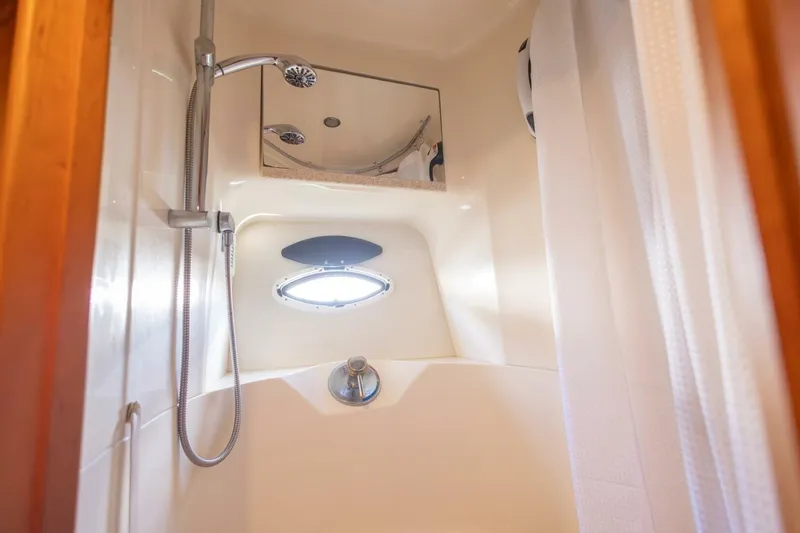 Blue Sapphire Yacht Photos Pics Shower area in 2001 Silverton 410 Sport Bridge yacht, featuring modern fixtures and porthole window.