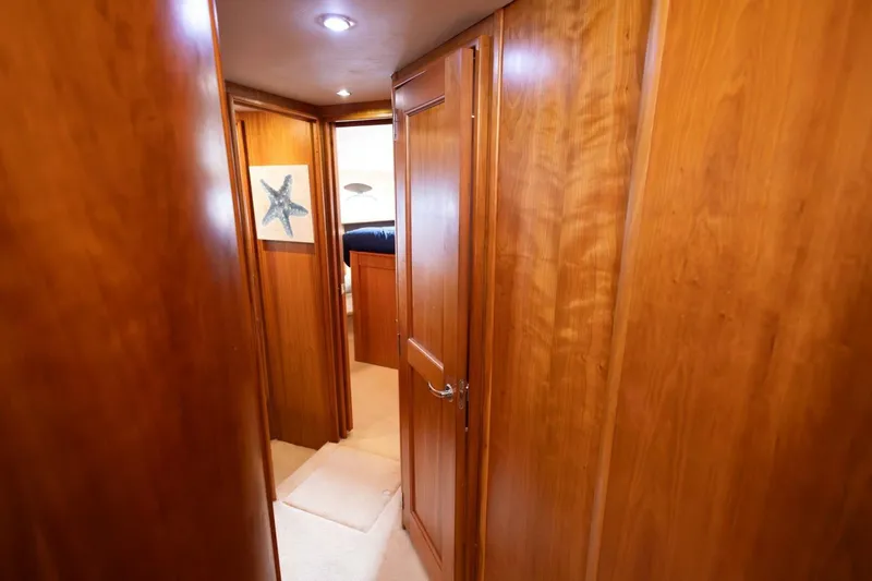 Blue Sapphire Yacht Photos Pics Interior hallway of 2001 Silverton 410 Sport Bridge with wooden paneling and starfish artwork.