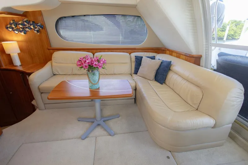 Blue Sapphire Yacht Photos Pics Luxurious interior of 2001 Silverton 410 Sport Bridge with cream leather seating and wooden table.