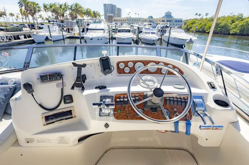 Blue Sapphire Yacht Photos Pics 2001 Silverton 410 Sport Bridge helm with marina view, featuring steering wheel and controls.