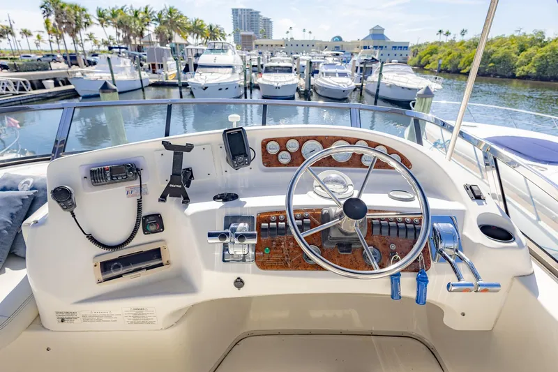 Blue Sapphire Yacht Photos Pics Helm of 2001 Silverton 410 Sport Bridge yacht at marina, featuring steering wheel and controls.