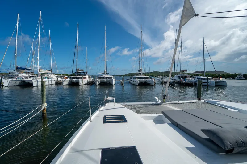 Hourglass Yacht Photos Pics 2020 Fountaine Pajot Saona 47 catamaran docked in a marina under a clear blue sky.