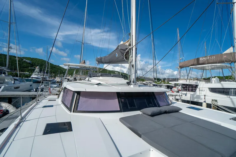Hourglass Yacht Photos Pics Fountaine Pajot Saona 47 catamaran, 2020 model, docked in a marina under clear blue skies.