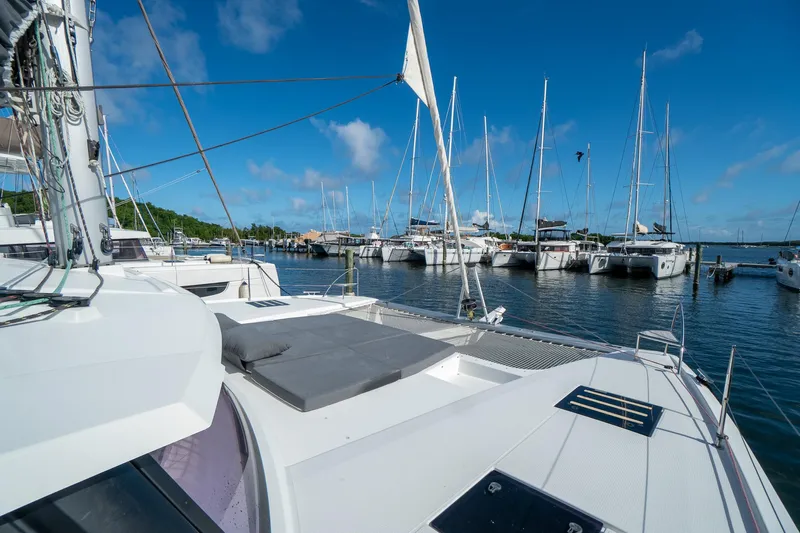 Hourglass Yacht Photos Pics 2020 Fountaine Pajot Saona 47 catamaran docked in a marina under a clear blue sky.