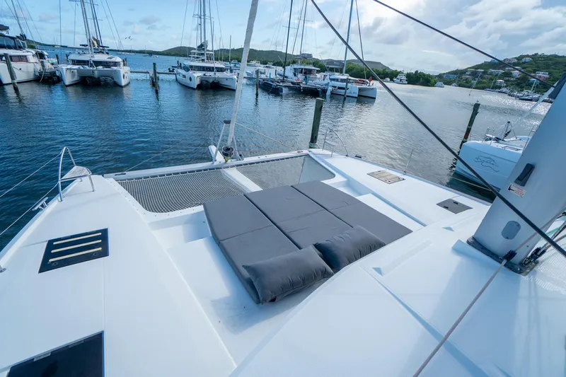 Hourglass Yacht Photos Pics 2020 Fountaine Pajot Saona 47 catamaran docked in a marina, featuring spacious deck and seating.