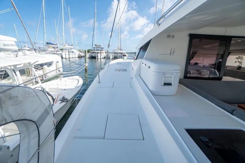 Hourglass Yacht Photos Pics 2020 Fountaine Pajot Saona 47 catamaran docked at marina, clear sky, spacious deck.