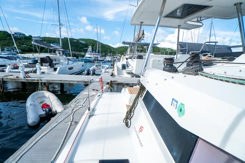 Hourglass Yacht Photos Pics 2020 Fountaine Pajot Saona 47 catamaran docked at a marina with other boats.