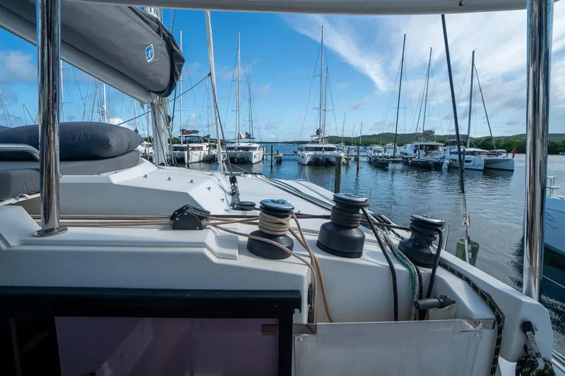 Hourglass Yacht Photos Pics 2020 Fountaine Pajot Saona 47 catamaran docked in a marina, surrounded by sailboats.