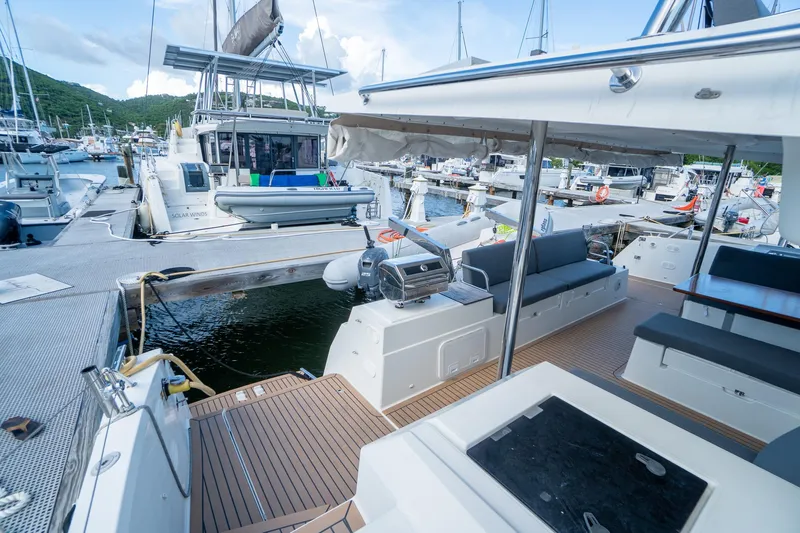 Hourglass Yacht Photos Pics 2020 Fountaine Pajot Saona 47 catamaran docked at marina, featuring spacious deck and seating area.