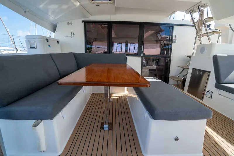 Hourglass Yacht Photos Pics 2020 Fountaine Pajot Saona 47 yacht interior with seating and wooden table.