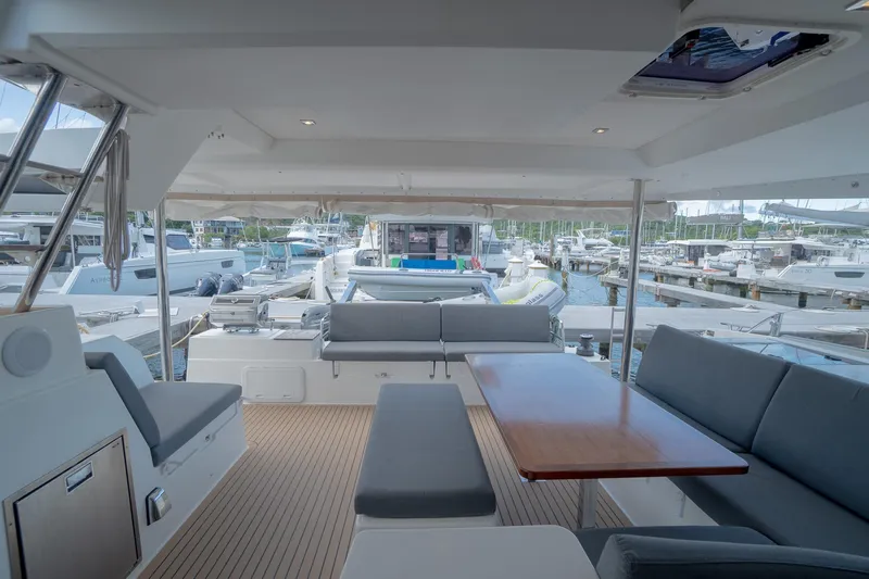 Hourglass Yacht Photos Pics 2020 Fountaine Pajot Saona 47 yacht interior with seating and table, docked at marina.