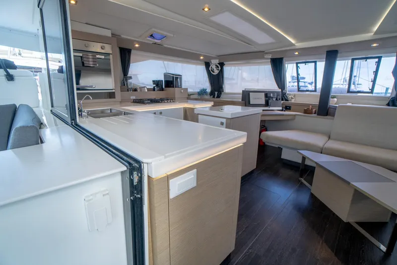 Hourglass Yacht Photos Pics Luxurious interior of 2020 Fountaine Pajot Saona 47 catamaran with modern kitchen and seating area.