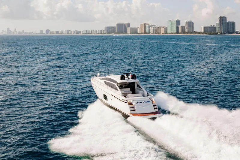 Sea Suite Yacht Photos Pics 2021 Pershing 62 yacht cruising near city skyline on open water.