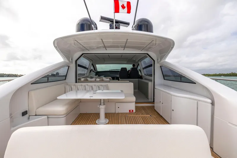 Sea Suite Yacht Photos Pics 2021 Pershing 62 yacht interior with seating, table, and Canadian flag.