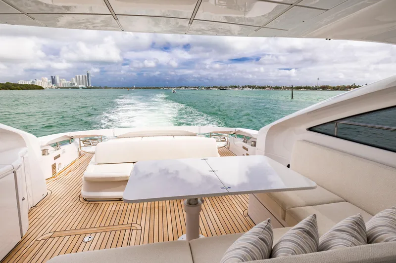 Sea Suite Yacht Photos Pics Luxurious 2021 Pershing 62 yacht cruising with city skyline and ocean view.