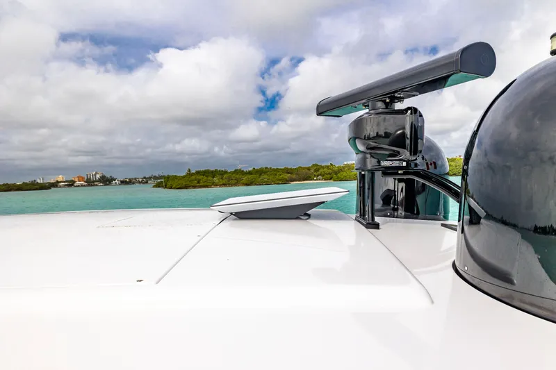 Sea Suite Yacht Photos Pics 2021 Pershing 62 yacht radar and equipment against scenic coastal backdrop.