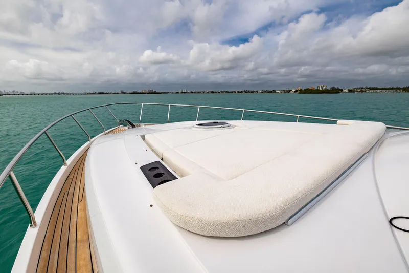 Sea Suite Yacht Photos Pics Luxury Pershing 62 yacht deck, 2021 model, cruising on turquoise waters under cloudy skies.