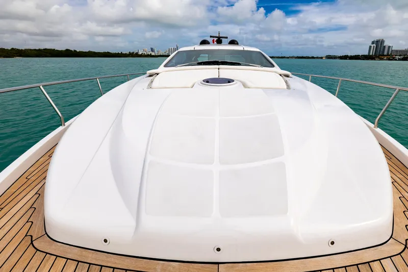 Sea Suite Yacht Photos Pics Luxury Pershing 62 yacht deck, 2021 model, cruising on turquoise waters under a partly cloudy sky.