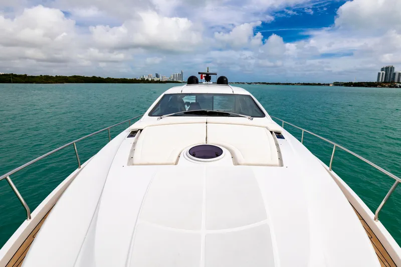 Sea Suite Yacht Photos Pics 2021 Pershing 62 yacht cruising on turquoise waters under a partly cloudy sky.