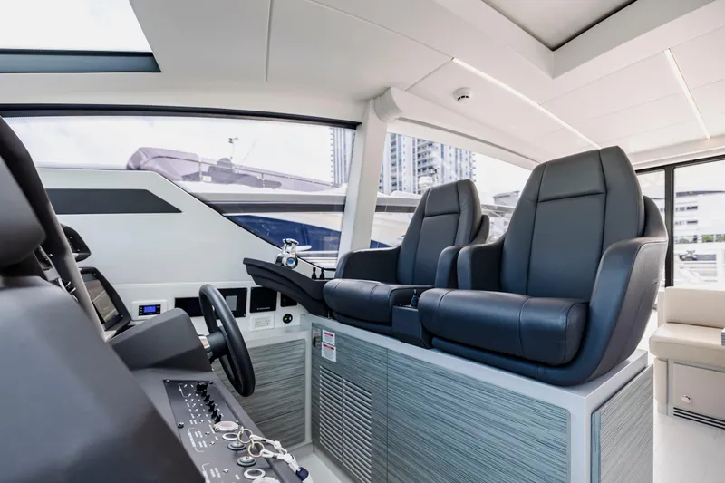 Sea Suite Yacht Photos Pics Luxurious interior of 2021 Pershing 62 yacht with sleek black seating and modern controls.