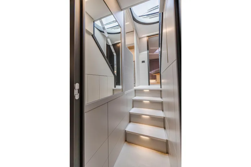 Sea Suite Yacht Photos Pics Modern interior staircase of 2021 Pershing 62 yacht with sleek design and ambient lighting.