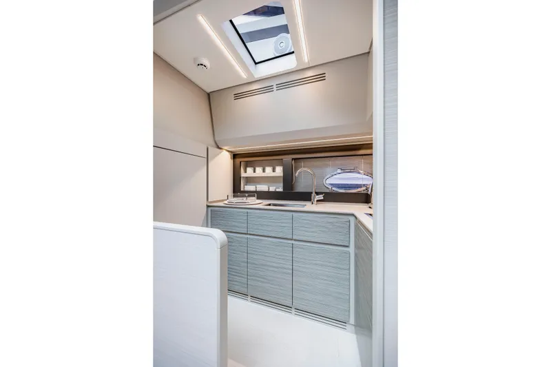 Sea Suite Yacht Photos Pics Modern kitchen interior of 2021 Pershing 62 yacht with sleek cabinetry and skylight.